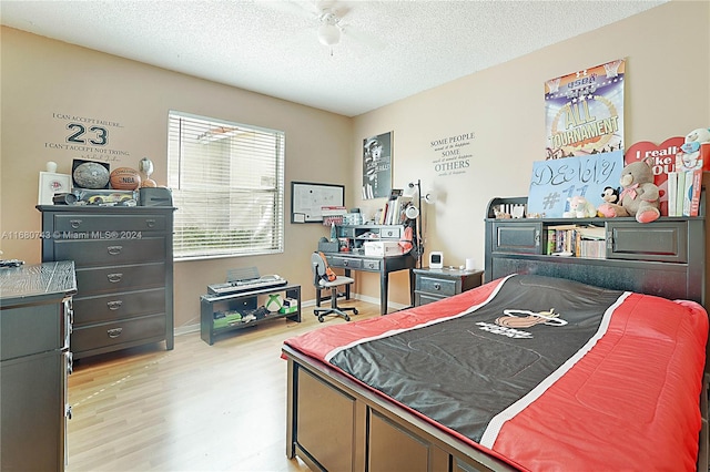 bedroom with a textured ceiling and light hardwood / wood-style flooring