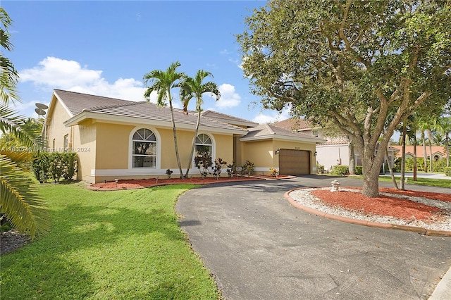 view of front of property featuring a front yard and a garage