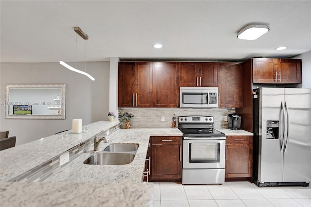 kitchen featuring sink, light stone counters, decorative light fixtures, light tile patterned floors, and appliances with stainless steel finishes