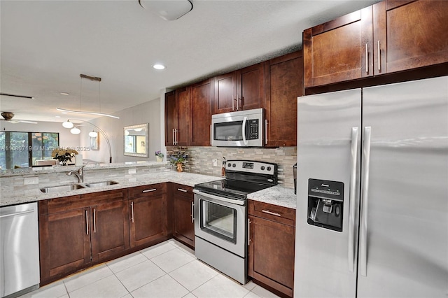 kitchen featuring decorative backsplash, light stone countertops, stainless steel appliances, ceiling fan, and sink