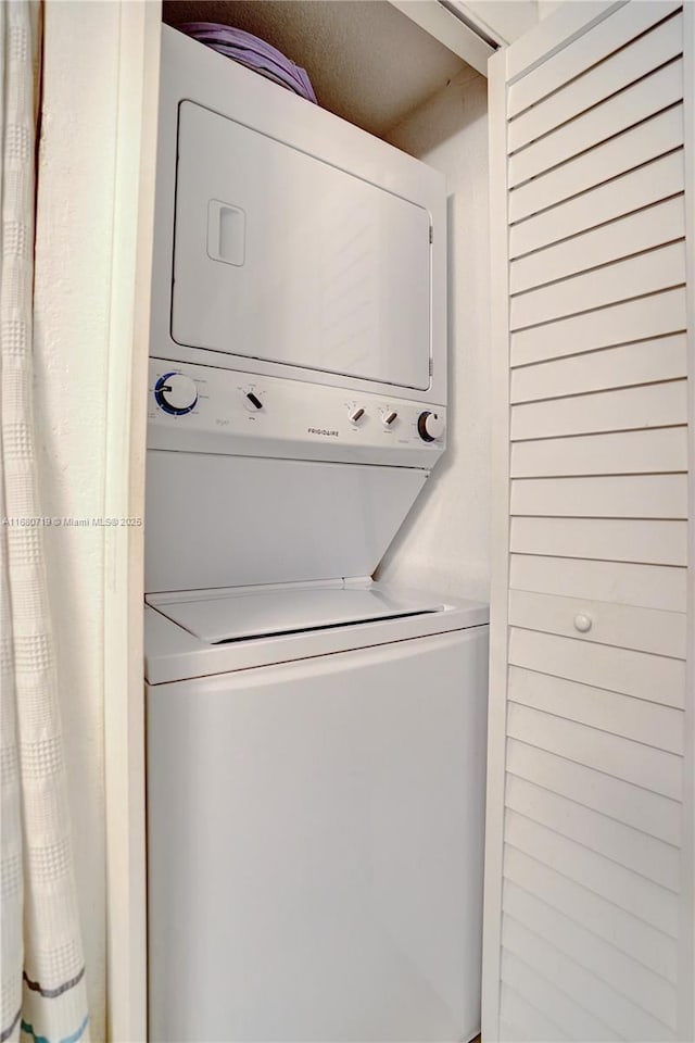 clothes washing area featuring stacked washer and dryer