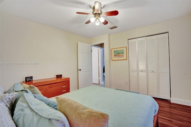 bedroom with dark hardwood / wood-style flooring, ceiling fan, and a closet