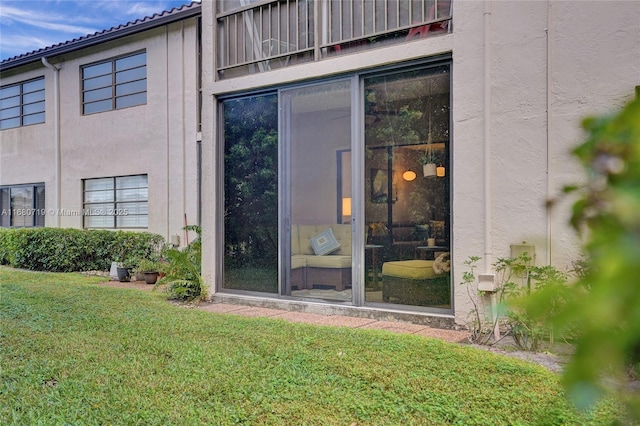 doorway to property with a lawn