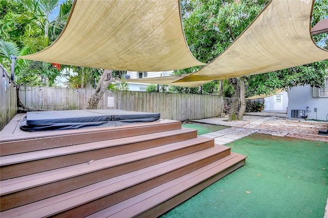 exterior space with central AC unit, a patio area, and a covered hot tub