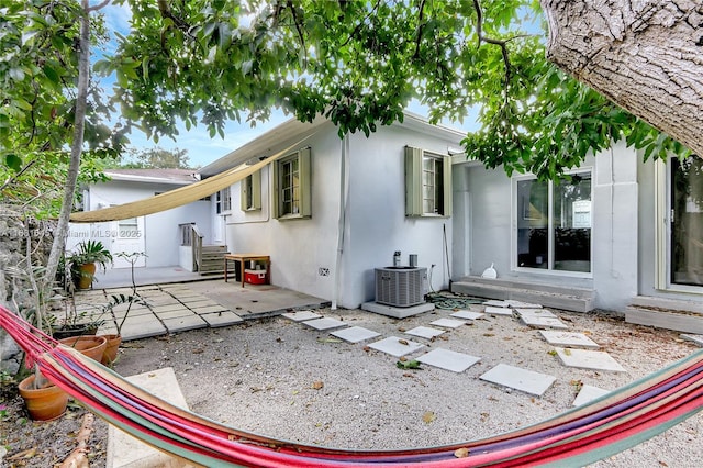 rear view of property featuring a patio area and central air condition unit