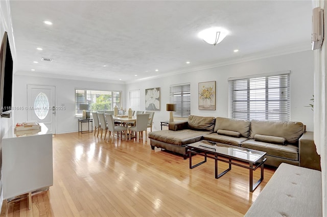 living room featuring ornamental molding and light hardwood / wood-style flooring