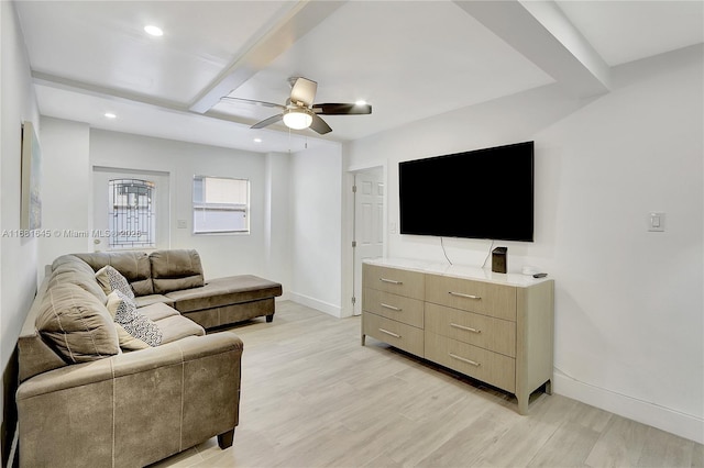 living room featuring beamed ceiling, ceiling fan, and light wood-type flooring