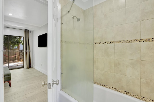 bathroom with tiled shower / bath combo and hardwood / wood-style floors