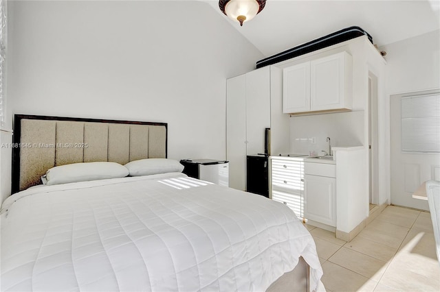 bedroom featuring light tile patterned flooring, lofted ceiling, and sink