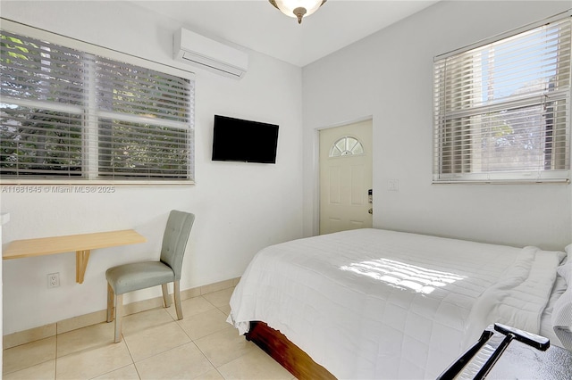 bedroom featuring light tile patterned floors and an AC wall unit