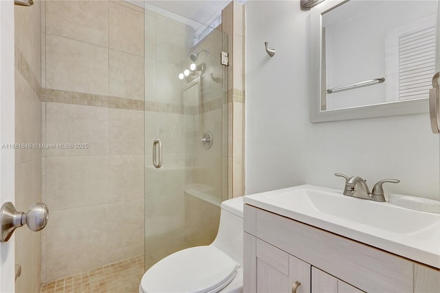 bathroom featuring vanity, a shower with shower door, and toilet