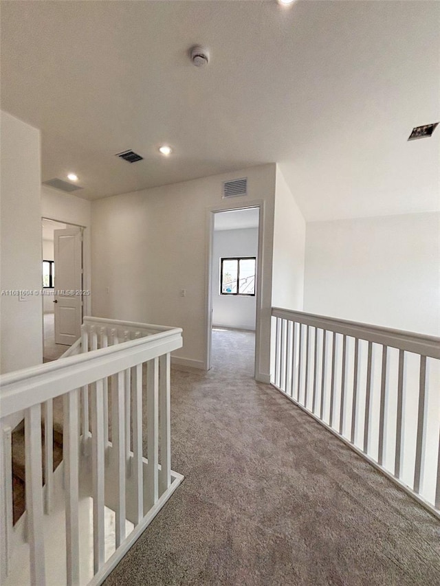 corridor featuring visible vents, recessed lighting, and carpet flooring