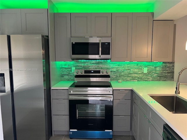 kitchen featuring gray cabinetry, sink, and stainless steel appliances