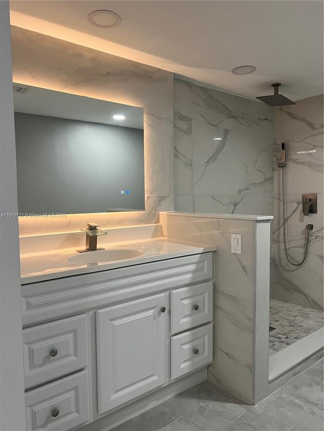 bathroom with vanity and a tile shower