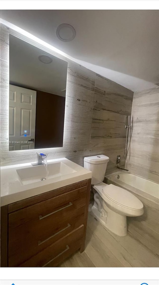 full bathroom featuring toilet, vanity, and bathing tub / shower combination