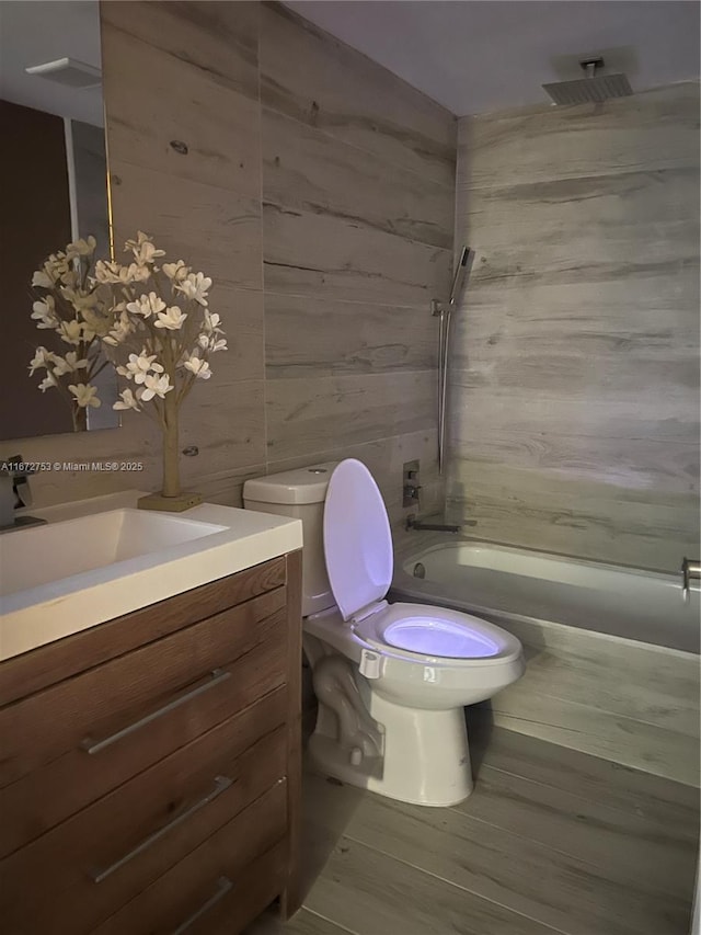 full bathroom featuring toilet, shower / washtub combination, wood-type flooring, and vanity