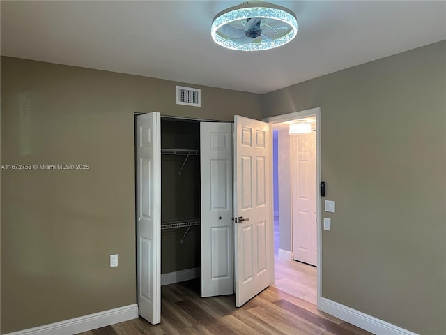 unfurnished bedroom with hardwood / wood-style floors and a closet