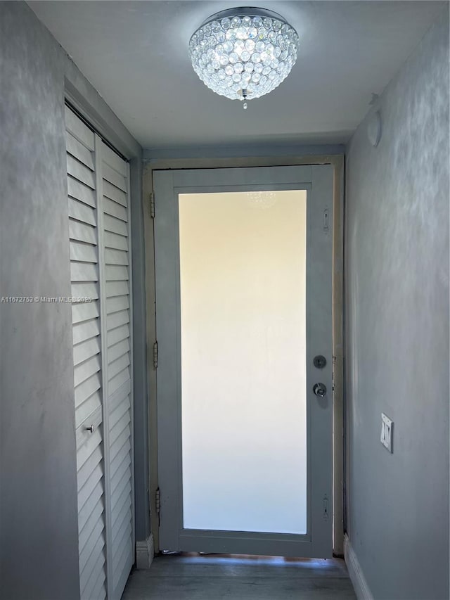 doorway to outside featuring a chandelier