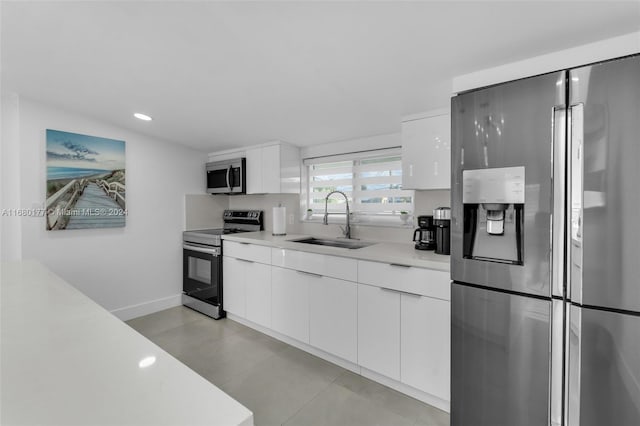 kitchen featuring appliances with stainless steel finishes, white cabinets, and sink