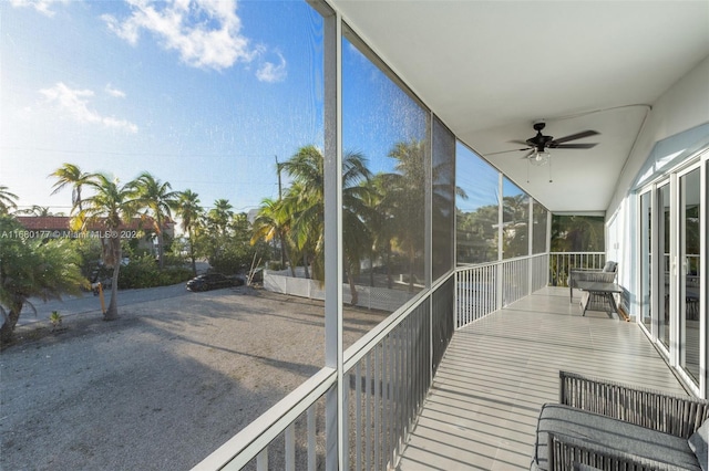 unfurnished sunroom with ceiling fan