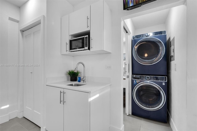 laundry room featuring stacked washer / dryer, sink, and light tile patterned floors