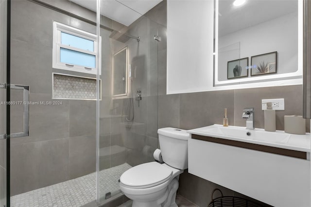 bathroom with vanity, an enclosed shower, toilet, and tile walls