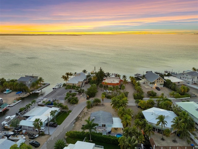 aerial view at dusk featuring a water view