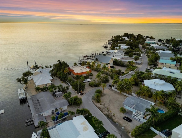 aerial view at dusk featuring a water view