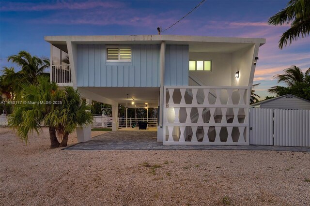 back house at dusk with a storage unit and a carport