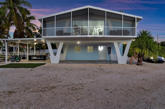 back house at dusk featuring a patio area