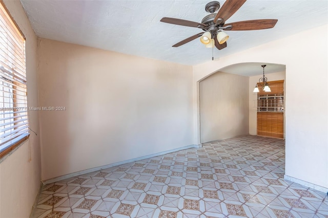 unfurnished room with a textured ceiling, light tile patterned floors, and ceiling fan