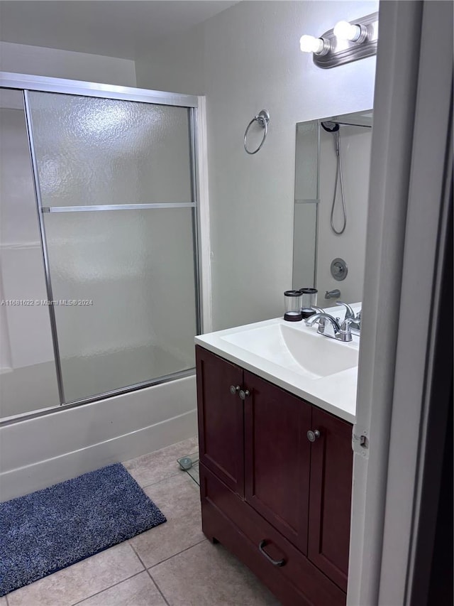 bathroom with enclosed tub / shower combo, tile patterned floors, and vanity