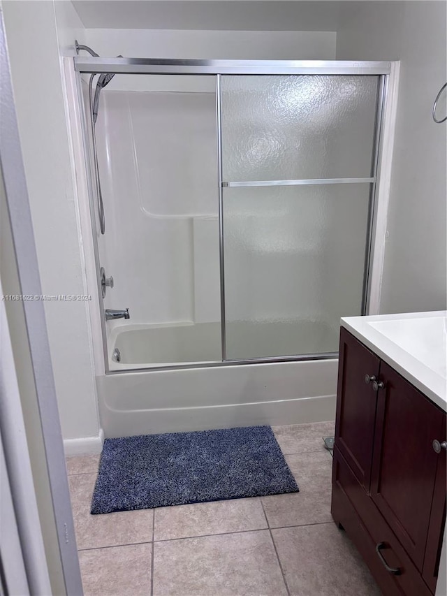 bathroom with tile patterned floors, shower / bath combination with glass door, and vanity