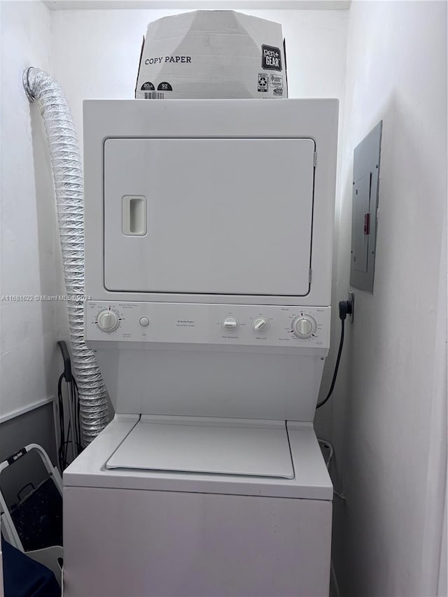 laundry area featuring stacked washer and clothes dryer and electric panel