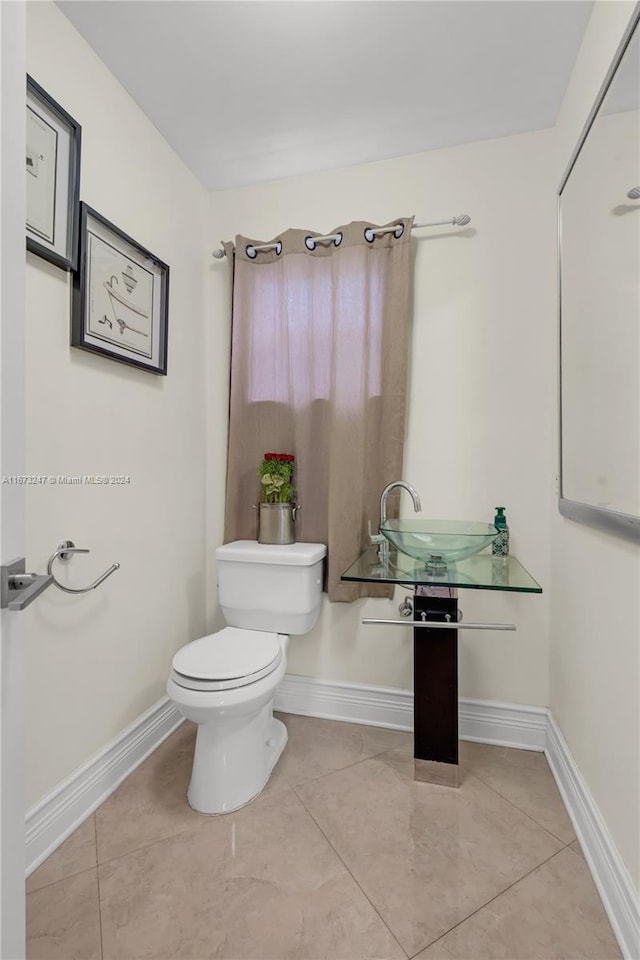 bathroom featuring toilet and tile patterned flooring