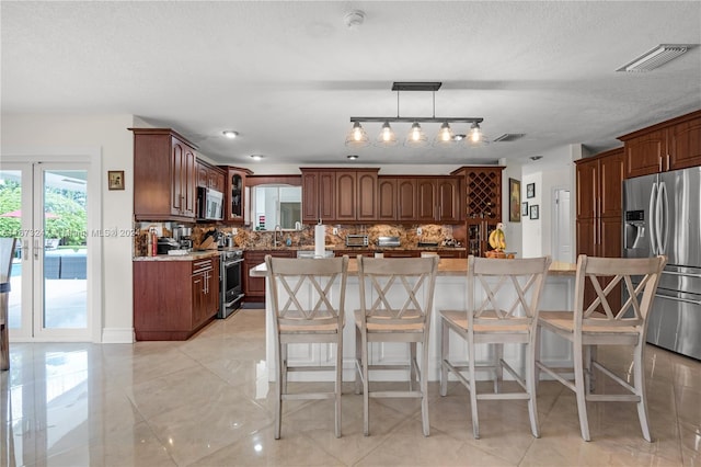 kitchen featuring backsplash, a kitchen breakfast bar, appliances with stainless steel finishes, and a center island