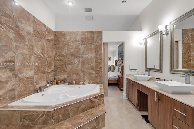 bathroom featuring vanity, tile walls, tiled tub, and tile patterned floors