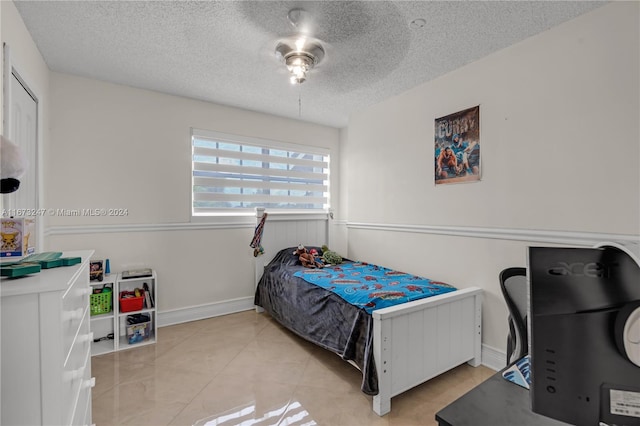 tiled bedroom featuring a textured ceiling and ceiling fan