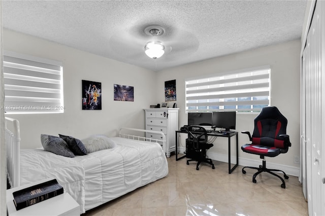 bedroom with a closet, ceiling fan, and a textured ceiling