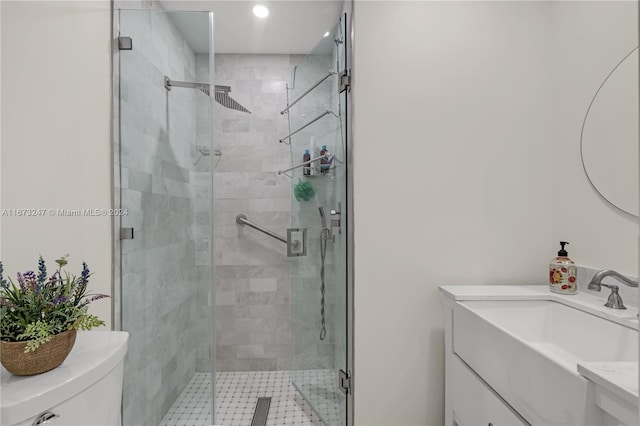 bathroom with vanity, toilet, and a shower with door