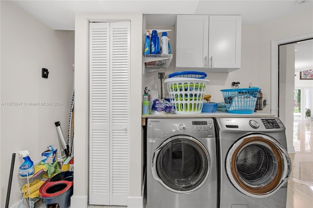 clothes washing area with separate washer and dryer and cabinets