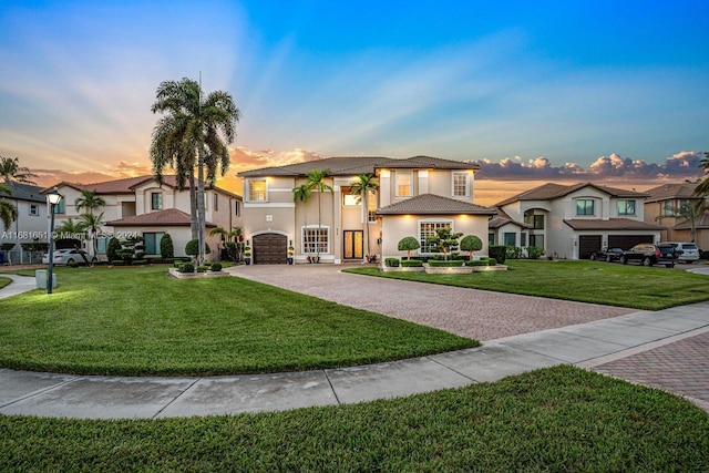 mediterranean / spanish-style house featuring a yard and a garage