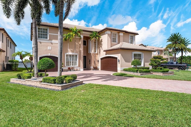 mediterranean / spanish-style house featuring a front yard and a garage