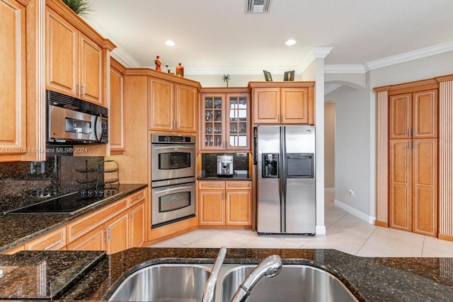 kitchen featuring dark stone counters, ornamental molding, black appliances, sink, and light tile patterned floors