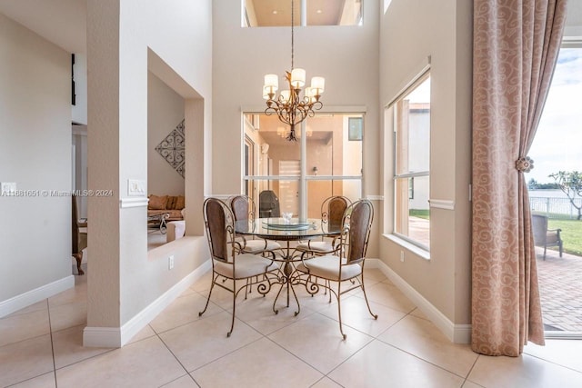 dining area featuring a notable chandelier, a towering ceiling, and light tile patterned floors