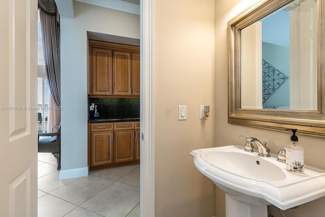 bathroom with tasteful backsplash, sink, and tile patterned flooring