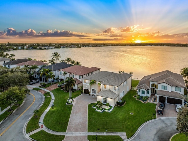 aerial view at dusk featuring a water view