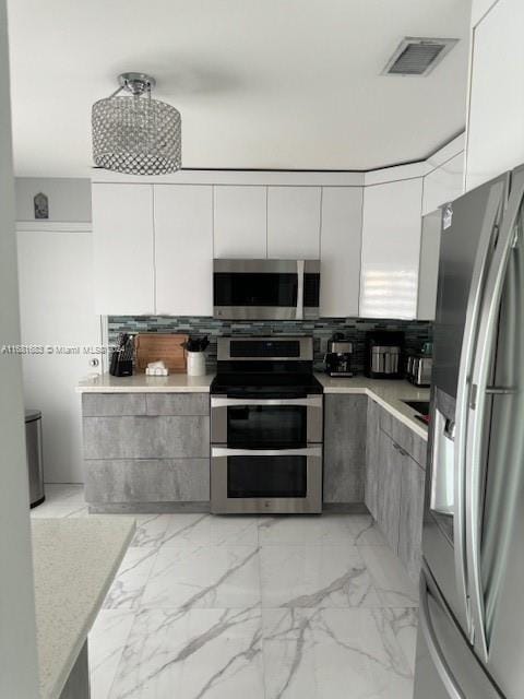 kitchen with gray cabinets and stainless steel appliances