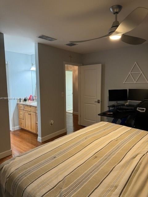 bedroom featuring ensuite bath, hardwood / wood-style flooring, and ceiling fan