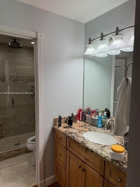 bathroom with toilet, walk in shower, and vanity